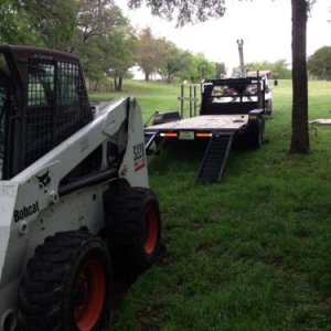 S 220 Bobcat Skidding on trailer.JPG